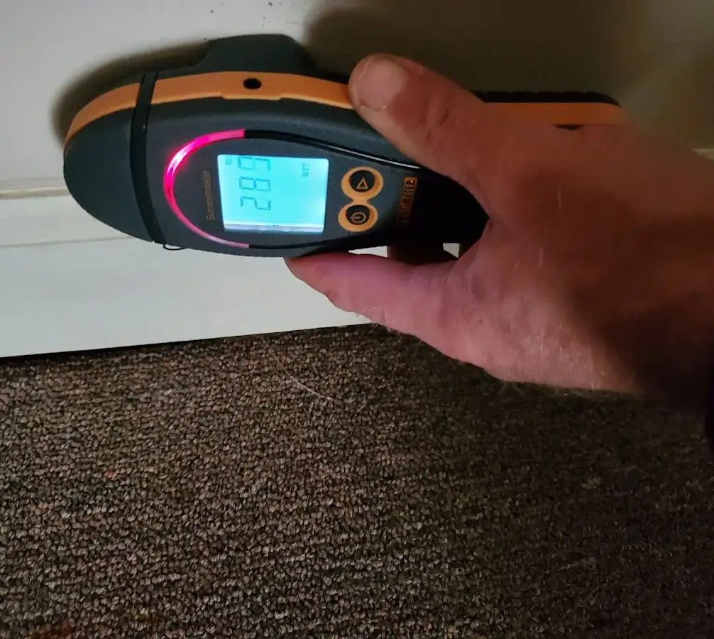 Moisture detection at baseboard during Storm Damage Restoration in Graham